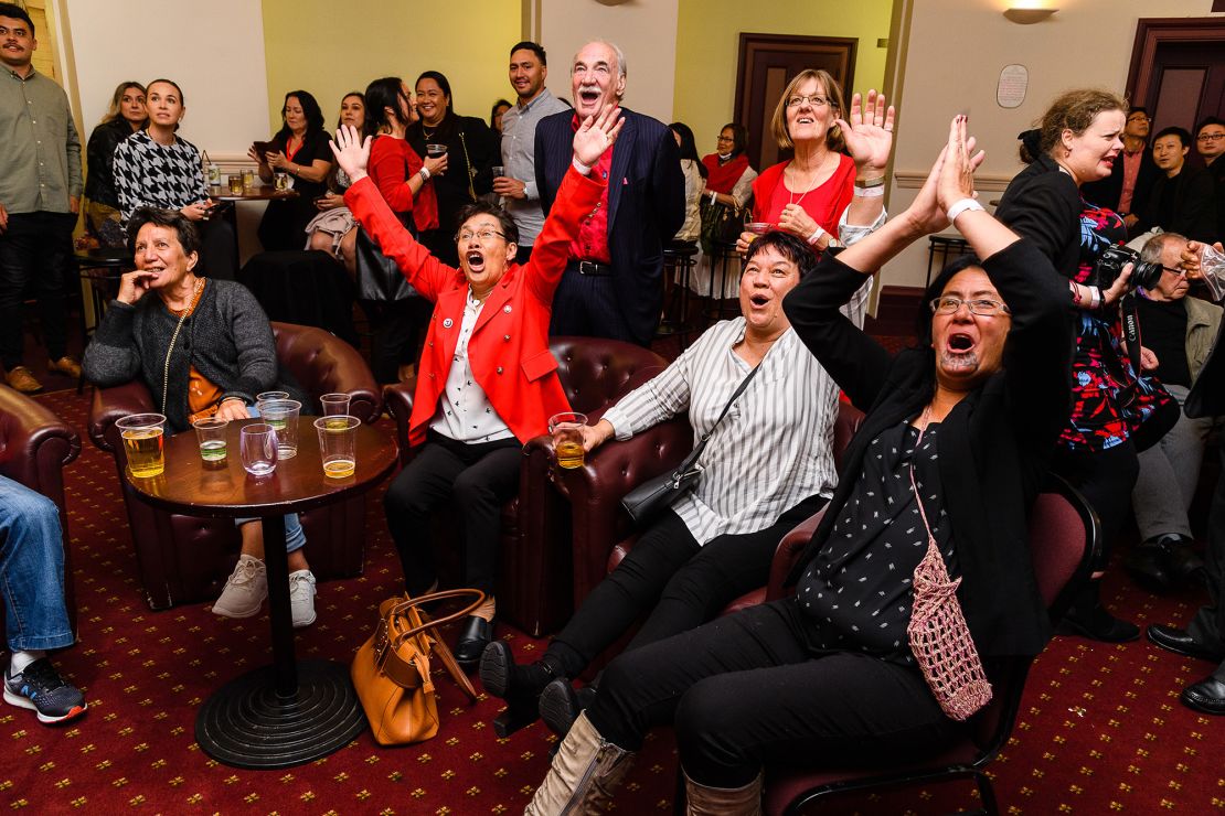 Labour Party supporters watch results come in and wait for Jacinda Ardern to arrive during an election night event at Auckland Town Hall in Auckland, New Zealand, on October 17, 2020. 