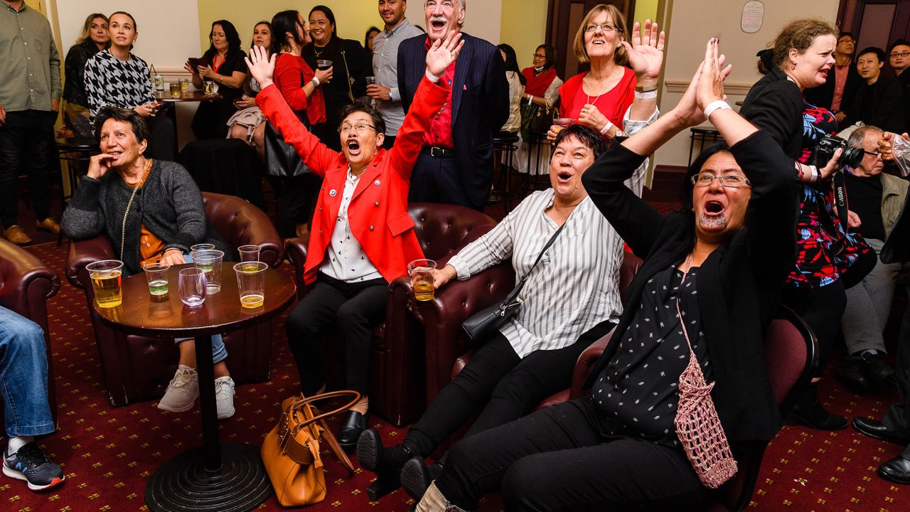 Labour Party supporters watch results come in and wait for Jacinda Ardern to arrive during an election night event at Auckland Town Hall in Auckland, New Zealand, on October 17, 2020. 