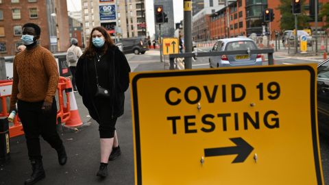 Pedestrians walk past a Covid-19 testing sign in Manchester on October 17.