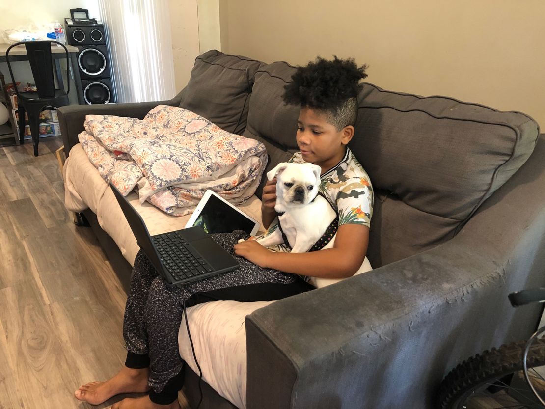 Jonelle Kilgore, 12, doing homework with his puppy Jasmine.