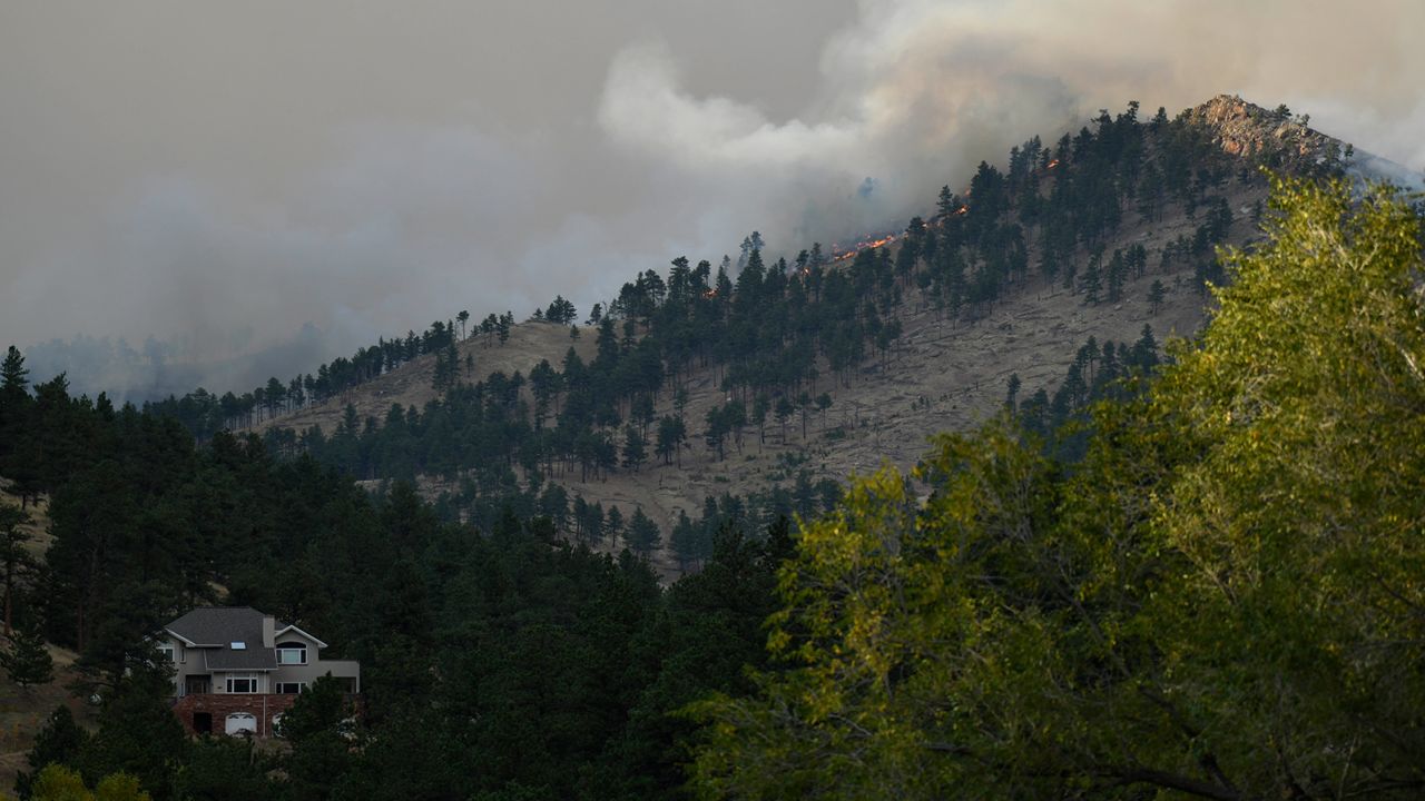The CalWood fire burns on a hillside sending up a large plume of smoke near Buckingham Park northwest of Boulder.