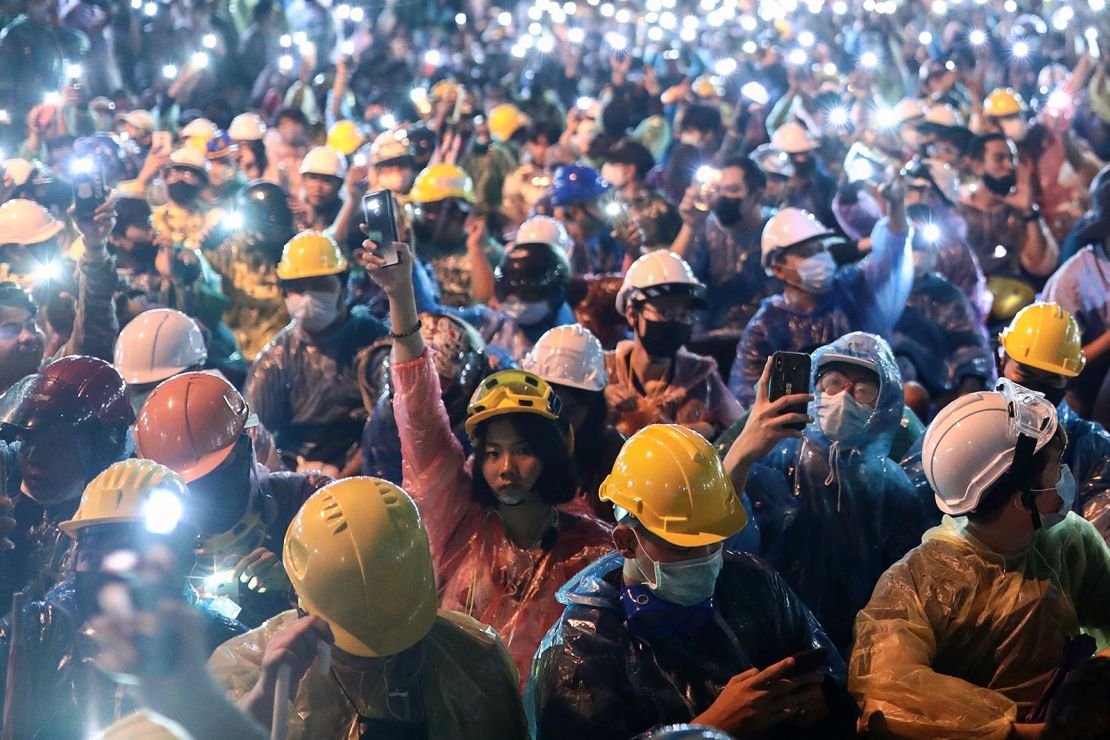 Pro-democracy protesters hold up the flashlights on their smartphones during an anti-government rally at Victory Monument in Bangkok on October 18.