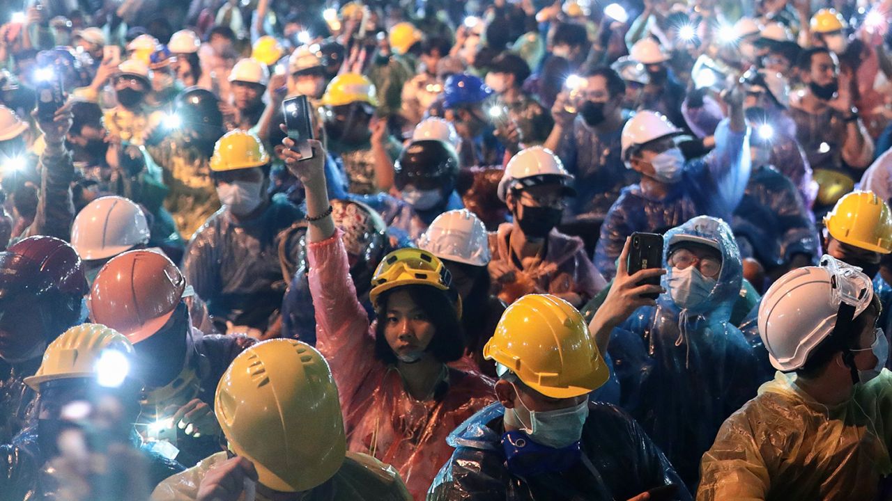 Pro-democracy protesters hold up the flashlights on their smartphones during an anti-government rally at Victory Monument in Bangkok on October 18.