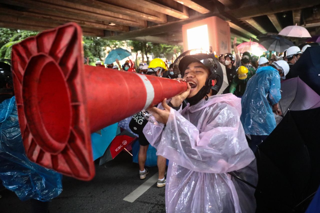 A pro-democracy protester jokingly uses a traffic cone as a loudpspeaker during an anti-government rally at Victory Monument in Bangkok on October 18.