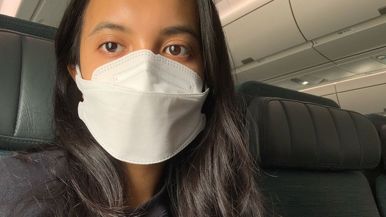 Karina Tsui, mask on, prepares to fly from the United States to Hong Kong.
