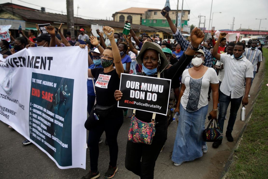 People hold banners as they demonstrate on the street to protest against police brutality in Lagos, Nigeria, Saturday Oct. 17, 2020.