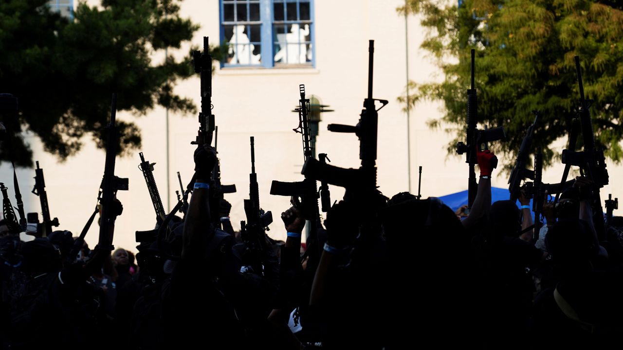 Members raised their weapons at Parc Sans Souci in Lafayette, Louisiana, on October 3.