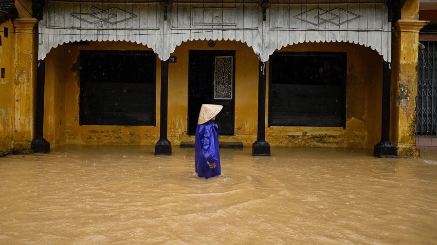 A woman wades though floodwaters along a street in central Vietnam's city of Hue on October 17, 2020. (Photo by Manan VATSYAYANA / AFP) (Photo by MANAN VATSYAYANA/AFP via Getty Images)