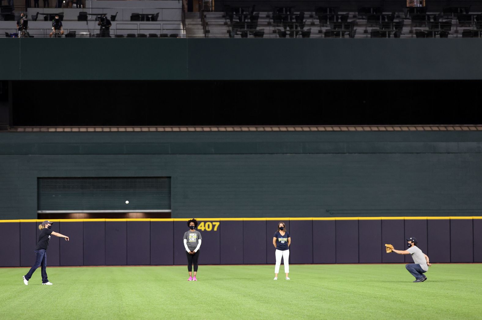 Nurse Jamie Edens, left, throws the ceremonial first pitch to her husband and fellow nurse Ryan Edens before Game 1. The couple was joined nurse Brittney Burns and nurse practitioner Erika Combs.