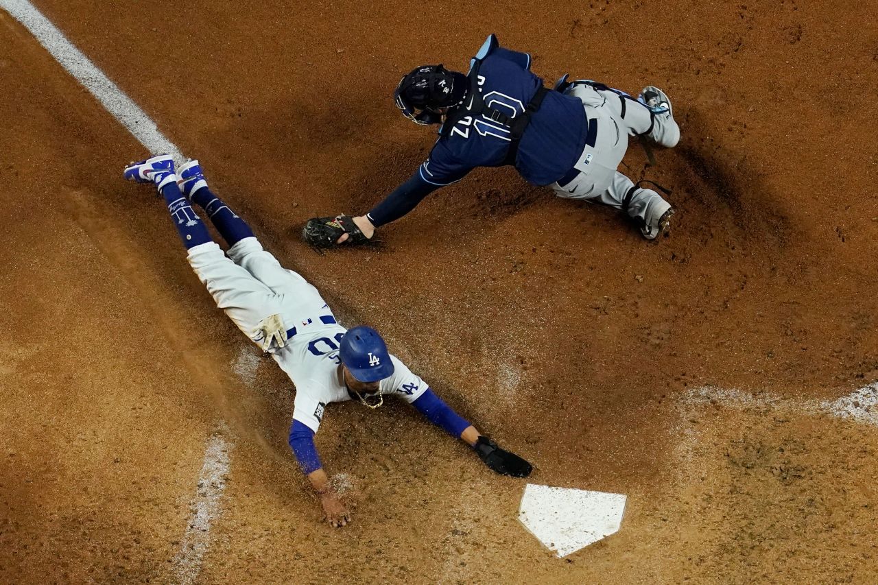 Dodgers outfielder Mookie Betts slides safely into home around the glove of Rays catcher Mike Zunino in the fifth inning.