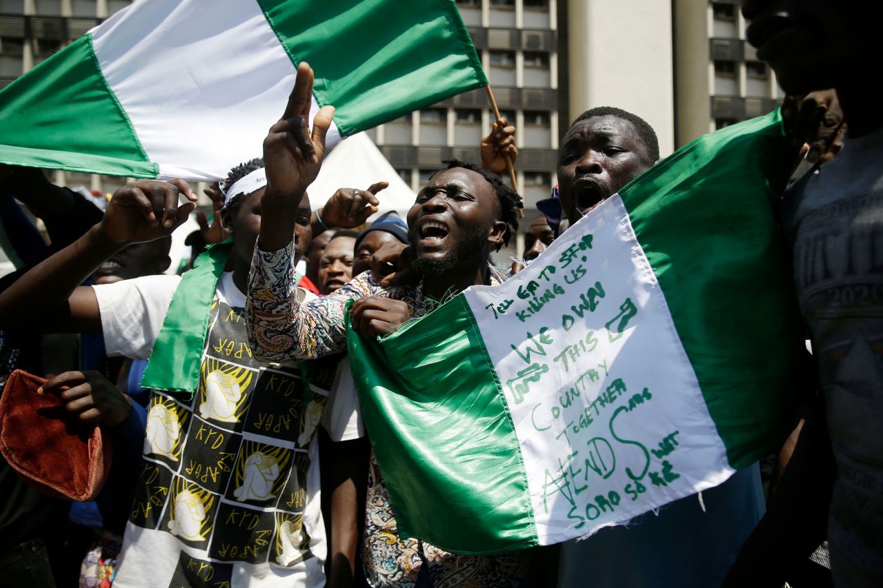People hold banners and flags as they protest in Lagos, Nigeria, on October 20.
