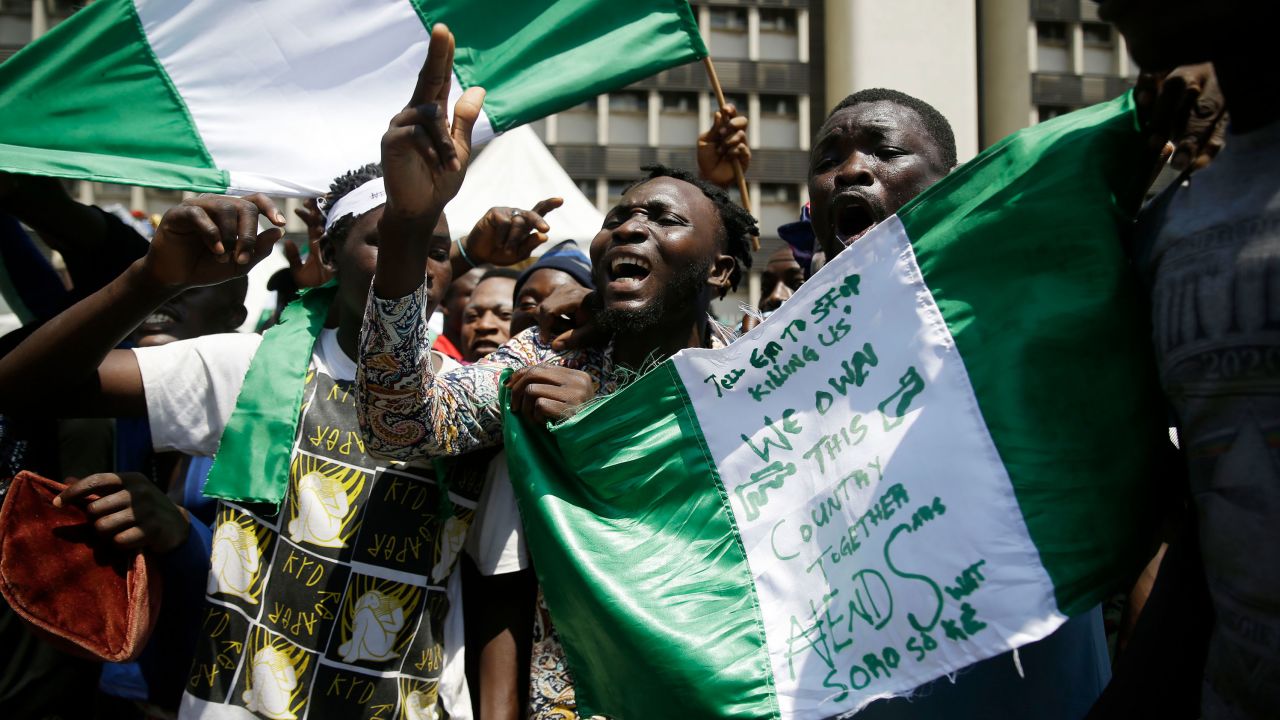 People hold up banners as they protest against police brutality in Lagos, Nigeria, on Tuesday.