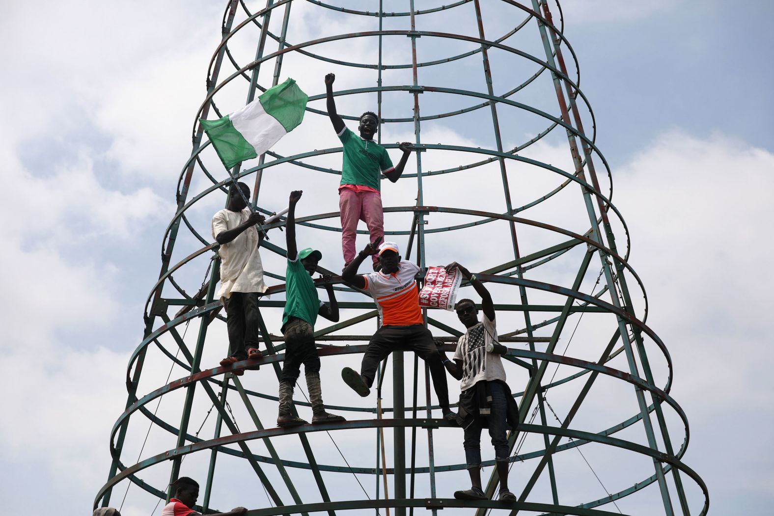 Protesters climb a telecommunications tower during a demonstration in Abuja on Monday, October 19.