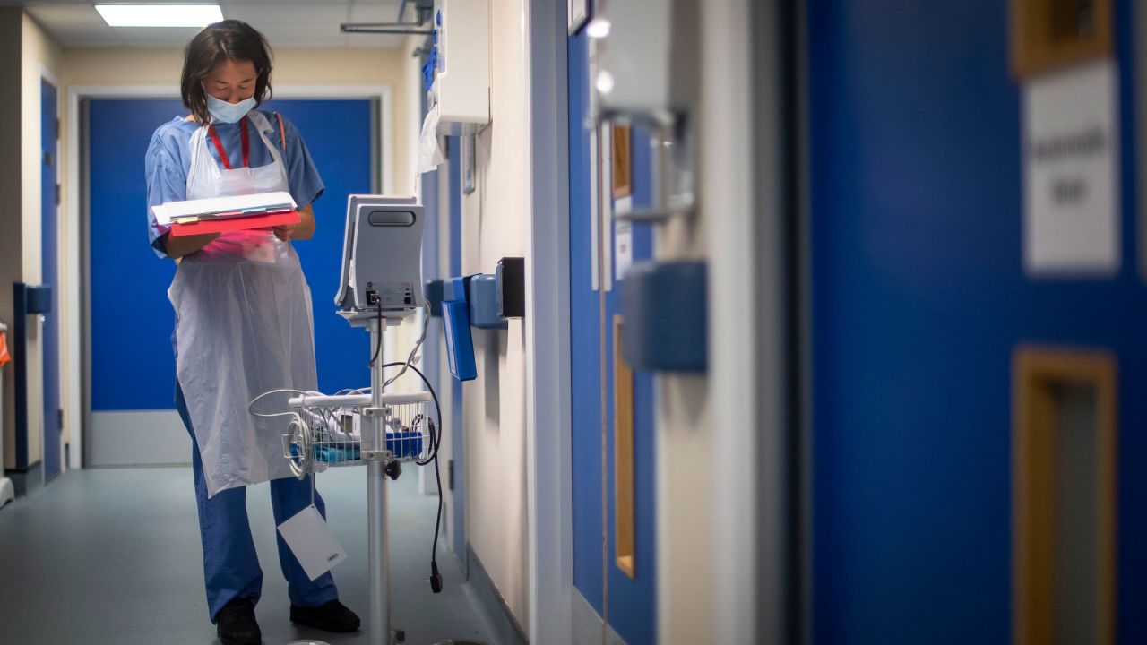 A doctor checks their notes as the first patients are admitted to the Seacole Centre, a converted old military hospital in Surrey, England, in May.