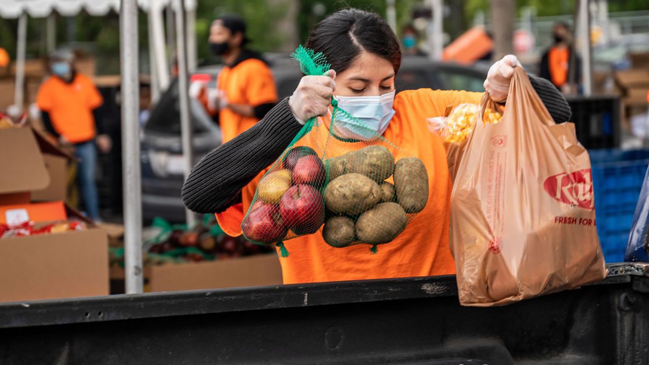 A volunteer for Second Harvest Food Bank of Orange County loads food into a car at a food distribution pop-up in Anaheim, California, on April 18.