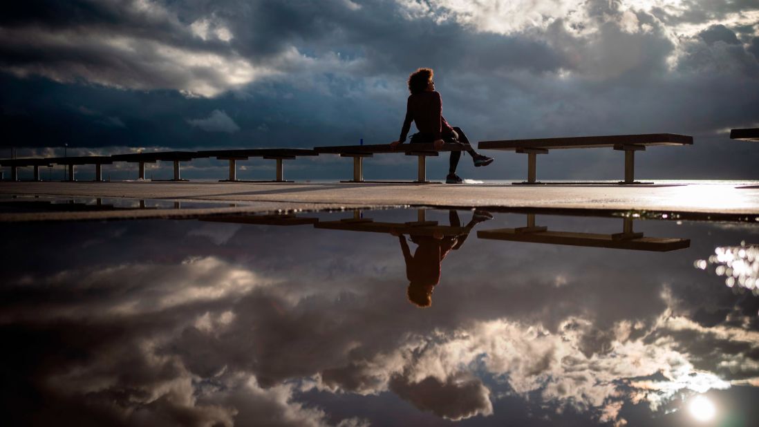<strong>Barcelona, Spain:</strong> A woman enjoys the calm after a storm on the Barcelona seafront on October 14. 