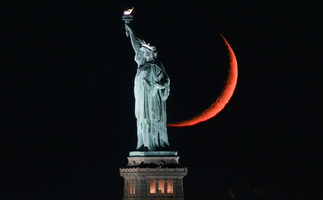 <strong>New York City, New York: </strong>On September 19, the Statue of Liberty gets caught between the moon and New York City. 