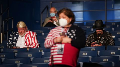 Professional golfer John Daly, left, and musician Kid Rock, supporters of the President, take their seats at the debate site.