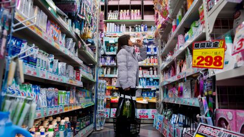 A woman browses products on a shelf in a discount store in the area of Shibuya in Tokyo, Japan, on March 1, 2013. 