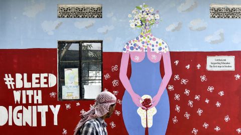 An Indian man looks on as he walks along a wall painting about female menstruation at the school for underprivileged children, Parijat Academy, on the Menstrual Hygiene Day in Guwahati on May 28, 2019. 
