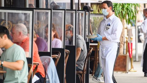 A waiter wears a face mask and rubber gloves outside Peter Luger Steakhouse in Brooklyn.