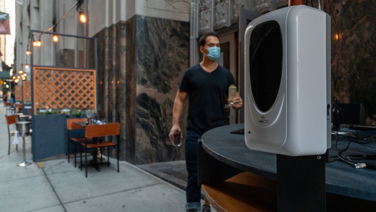 A hand sanitizer dispenser is stationed in the outside dining area of Crown Shy restaurant in New York.