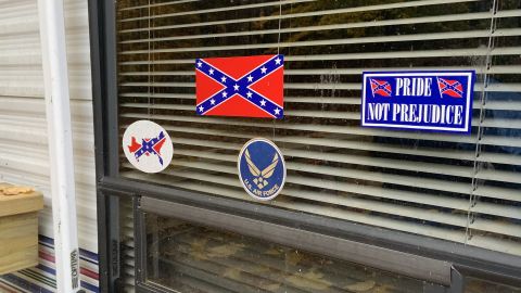 Confederate symbols and a US Air Force sticker adorn a window at the mobile home.