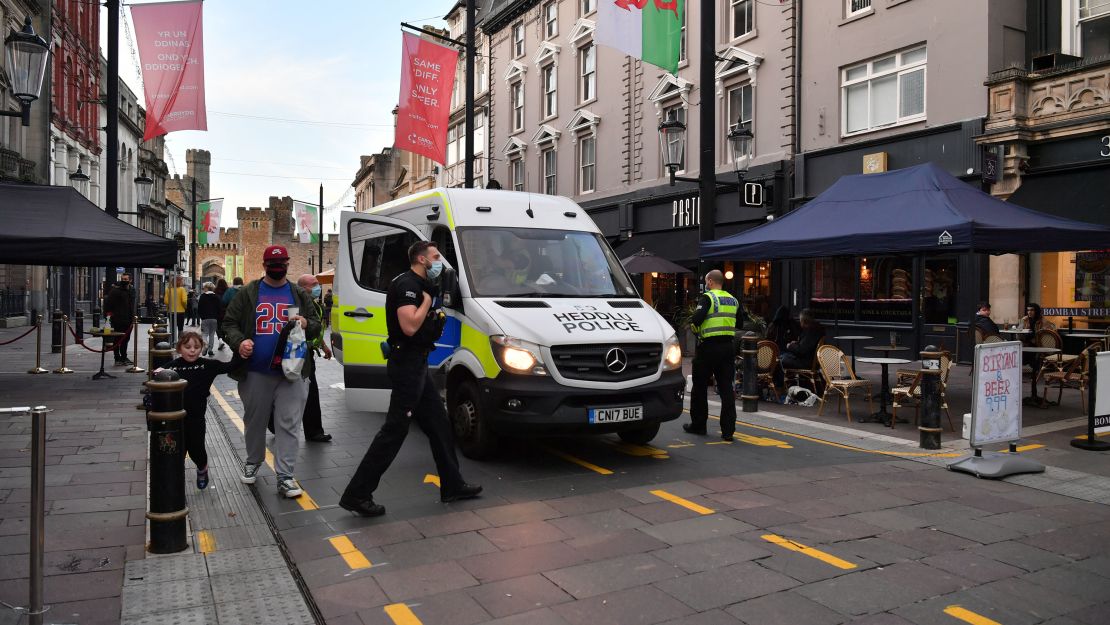 Police officers patrol the center of Cardiff before Wales enters lockdown for a second time.