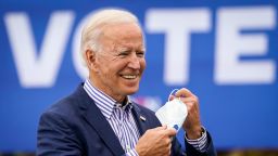 Democratic presidential nominee Joe Biden takes off his face mask to speak during a drive-in campaign rally at Bucks County Community College on October 24, 2020 in Bristol, Pennsylvania. Biden is making two campaign stops in the battleground state of Pennsylvania on Saturday.