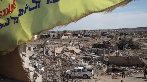 A Syrian Defence Force (SDF) flag flies over the destroyed ISIL encampment on March 23, 2019 in Baghouz, Syria. 