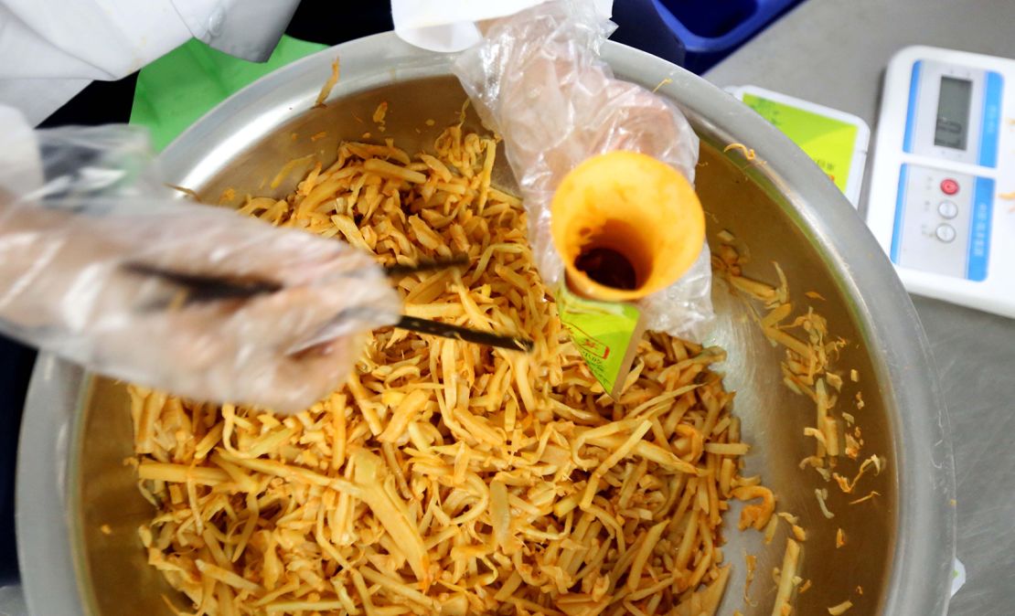 A Chinese worker packs pickled bamboo shoots, which give luosifen its distinctive smell.  