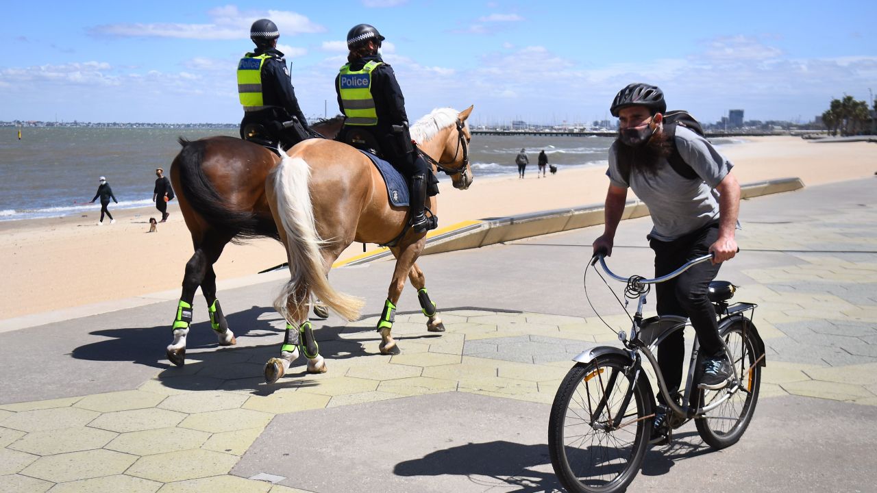 Police patrol on horseback along the St Kilda Esplanade in Melbourne on October 26, 2020. The city was previously at the epicenter of Australia's coronavirus outbreak. 