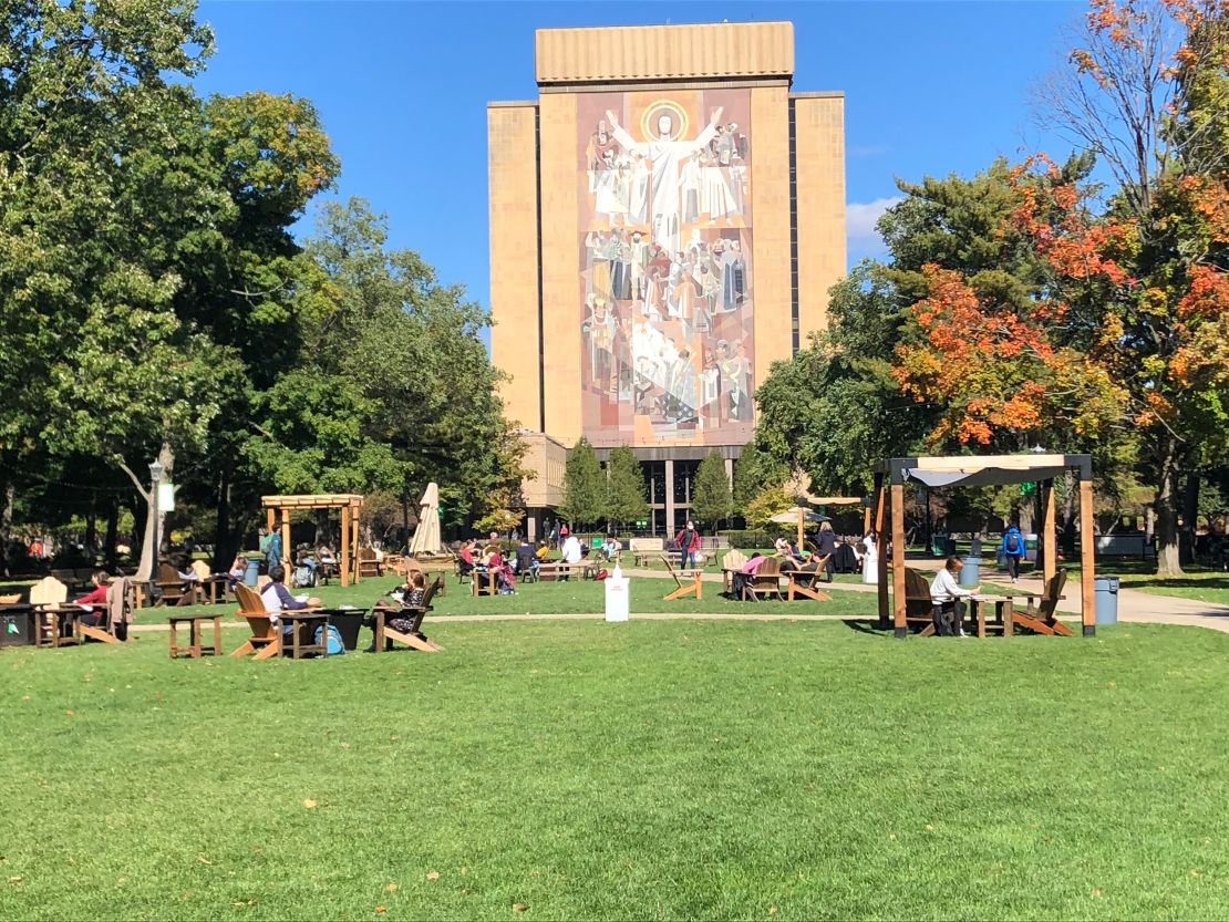 Students sit outside and take a break between classes on the campus of Notre Dame University in South Bend, Indiana on October 6, 2020.