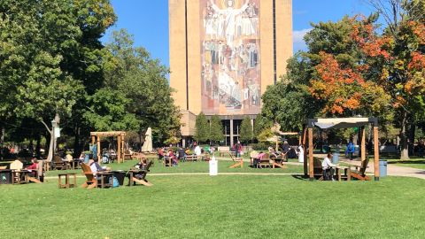 Students sit outside and take a break between classes on the campus of Notre Dame University in South Bend, Indiana on October 6, 2020.