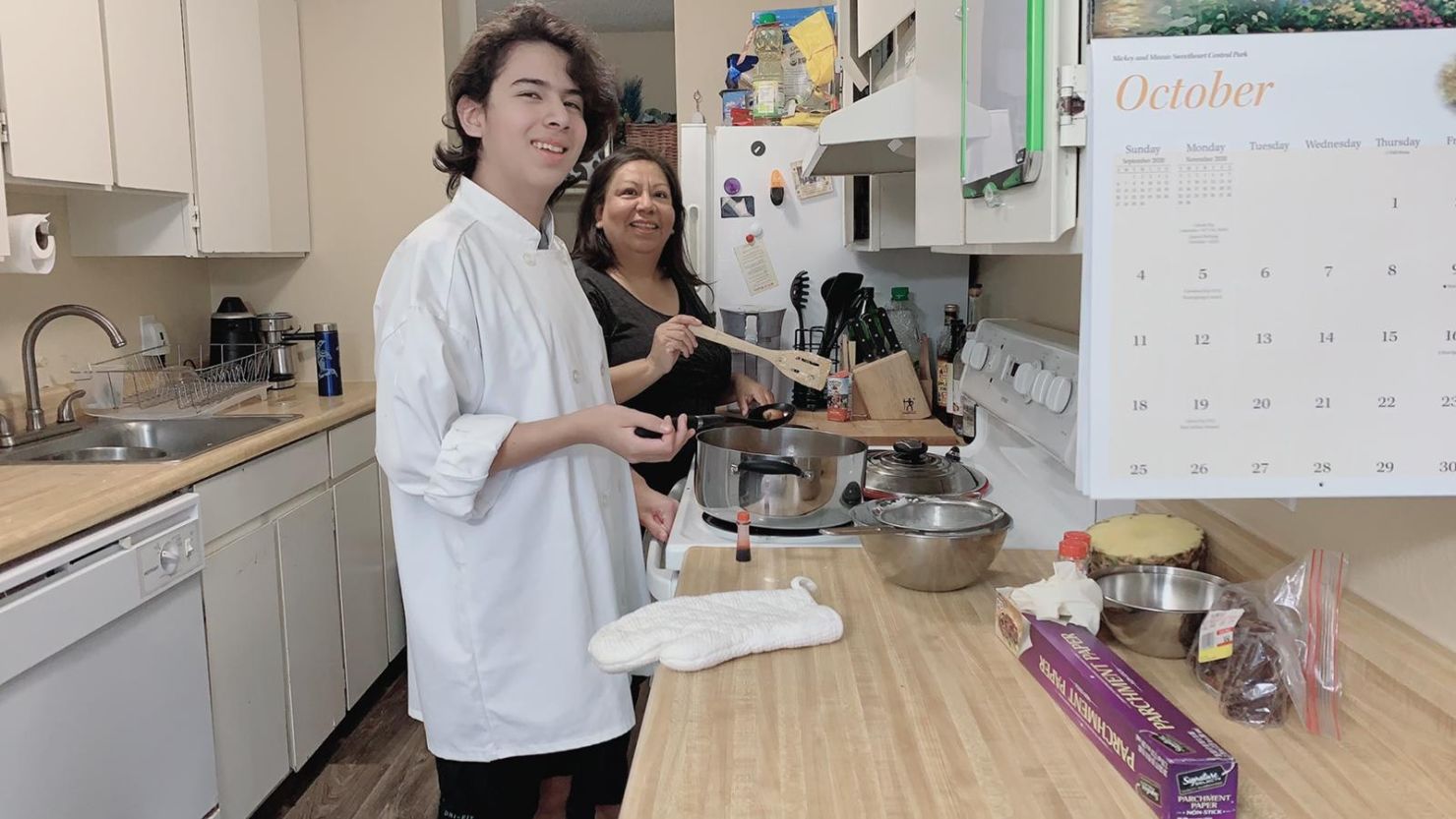 Laura Gonzalez (right) of Seattle, and Marcos, her 13-year-old son (left), cook special weekend meals. She said he is responsible with his distance learning, but she worries he's home alone while she works.