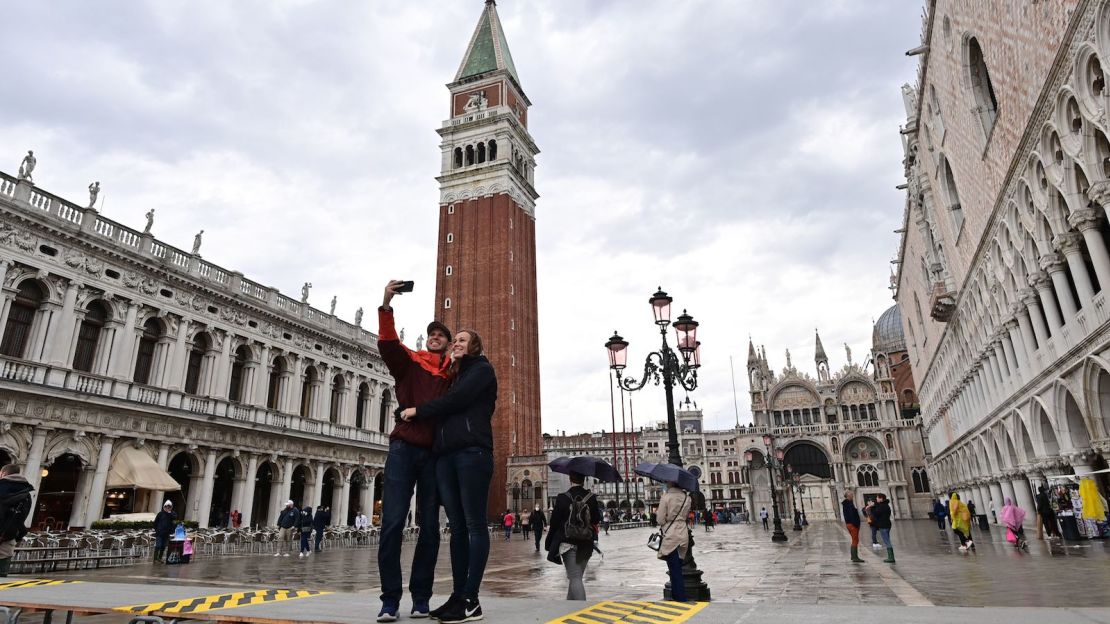 A couple takes a selfie in Venice's normally bustling St. Mark's Square on October 3, 2020.
