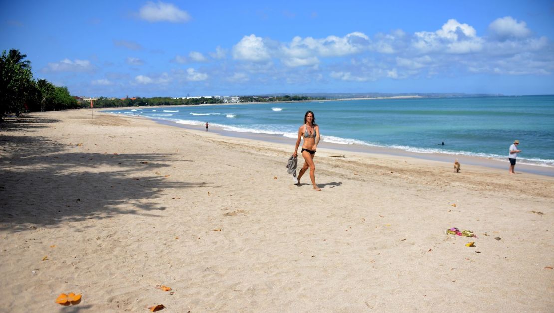 A woman walks along Kuta Beach on the Indonesian resort island of Bali on August 15, 2020. 