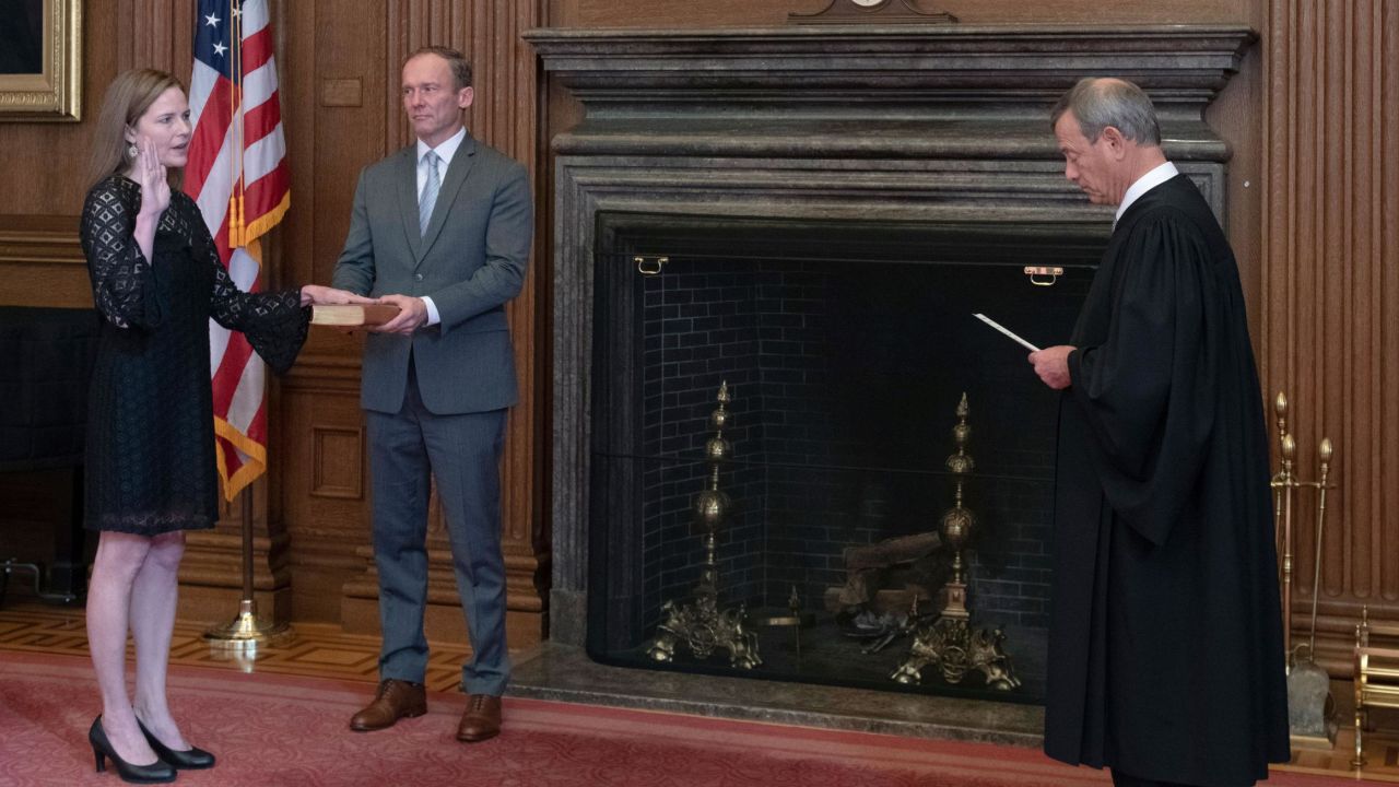 Chief Justice John G. Roberts, Jr., administers the Judicial Oath to Judge Amy Coney Barrett in the East Conference Room, Supreme Court Building. Judge Barrett's husband, Jesse M. Barrett, holds the Bible.