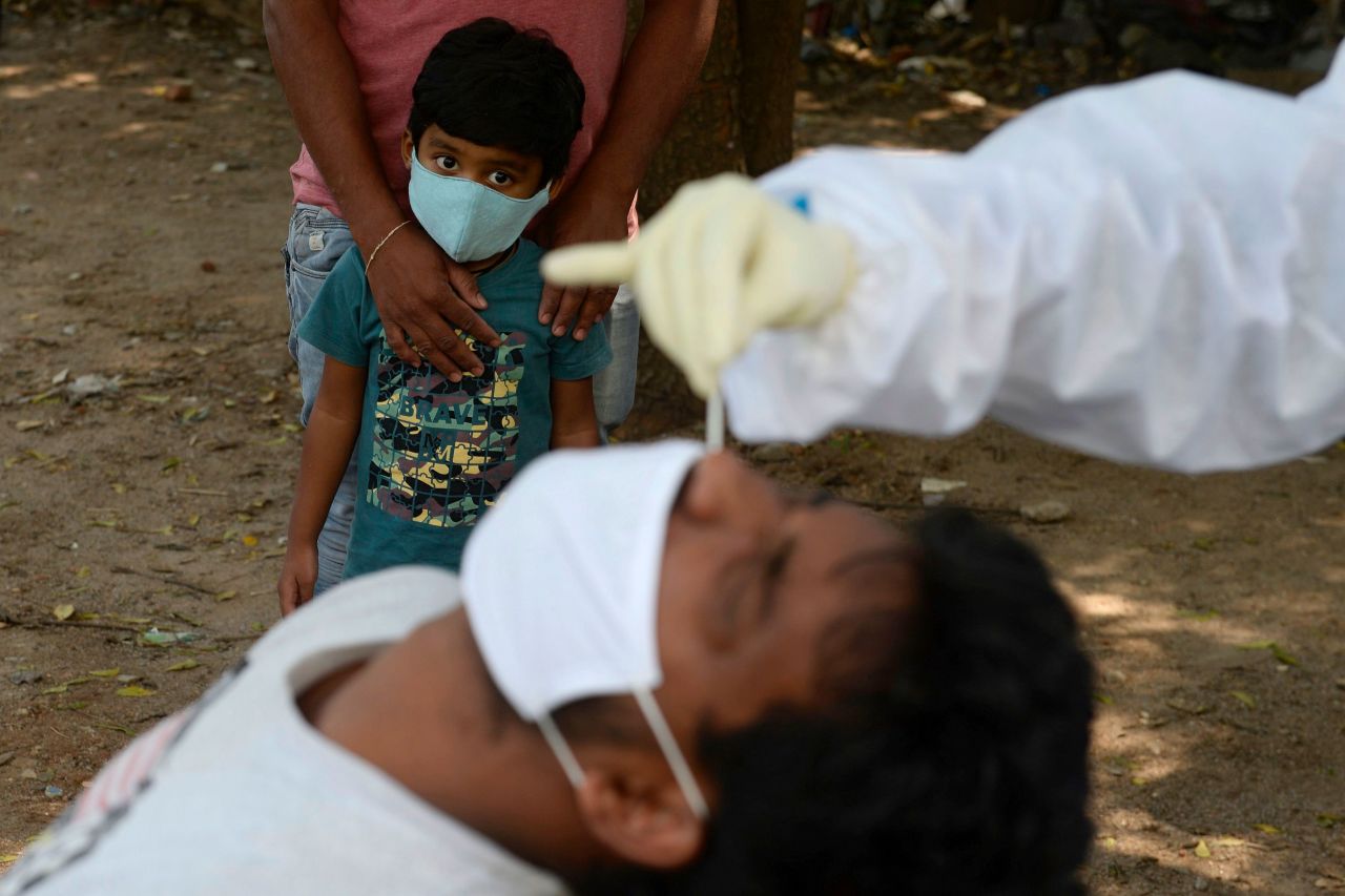A boy watches as a health worker tests someone for Covid-19 in Hyderabad, India, on October 27.