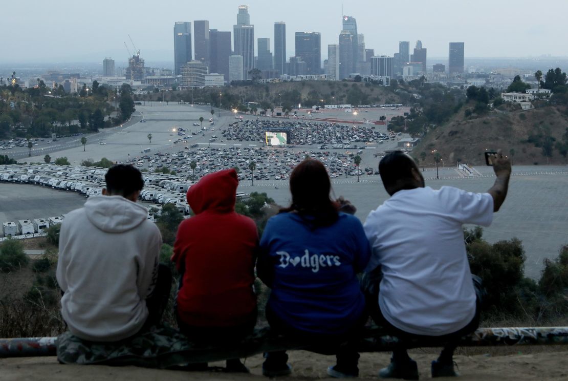 Dodgers fans gather on an overlook as people attend a drive-in screening of Game 3 of the 2020 World Series between the Los Angeles Dodgers and the Tampa Bay Rays at a Dodger Stadium parking lot on October 23, 2020 in Los Angeles, California.