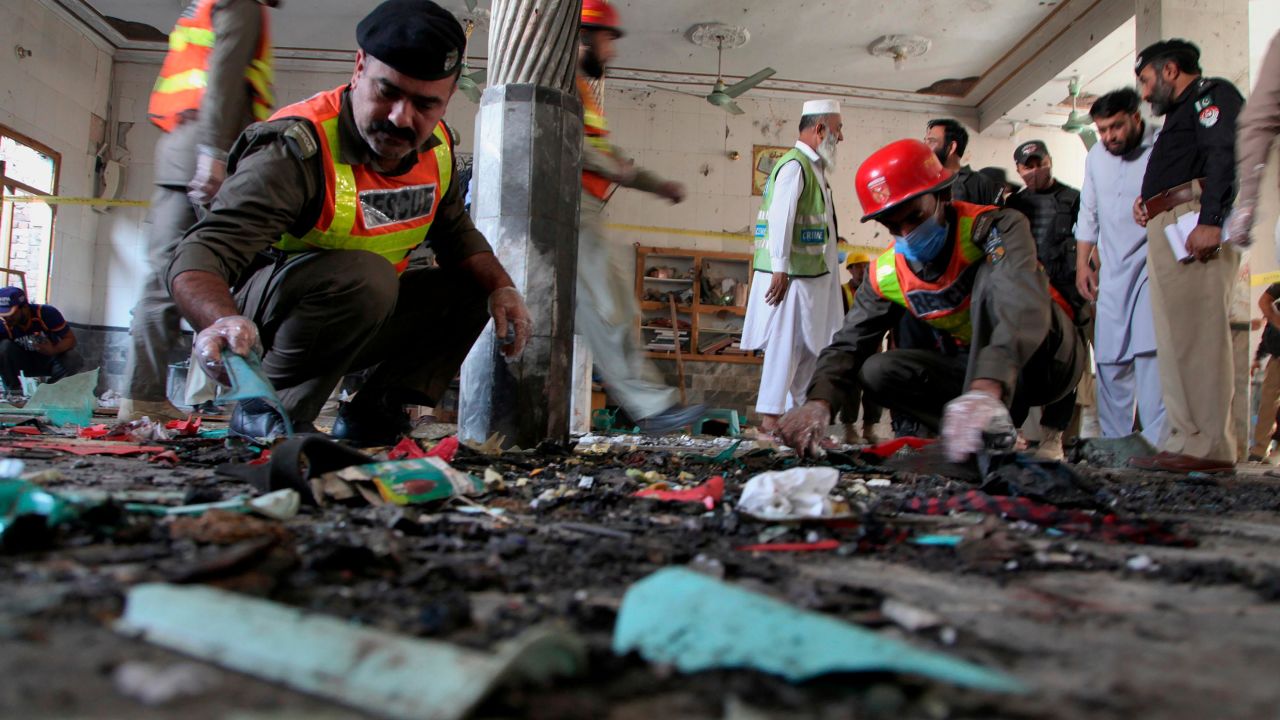 Pakistani rescue workers and police officers examine the site of a bomb explosion in an Islamic seminary, in Peshawar, Pakistan, Tuesday, Oct. 27, 2020.