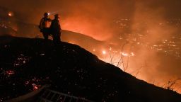TOPSHOT - Firefighters look out over a burning hillside as they fight the Blue Ridge Fire in Yorba Linda, California, October 26, 2020. - Some 60,000 people fled their homes near Los Angeles on October 26 as a fast-spreading wildfire raged across more than 7,200 acres (3,000 hectares), blocking key roadways and critically injuring two firefighters. (Photo by Robyn Beck / AFP) (Photo by ROBYN BECK/AFP via Getty Images)