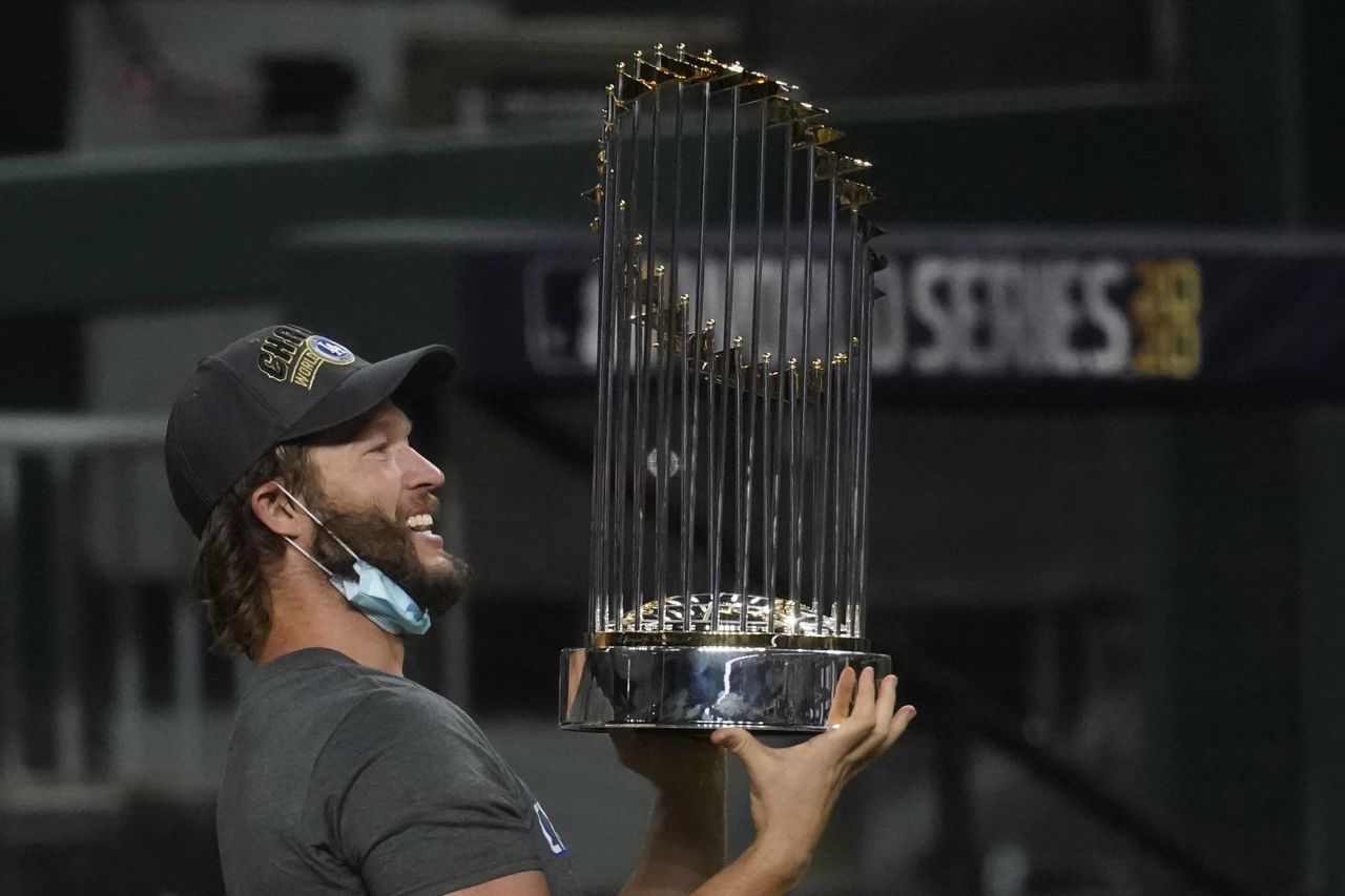 Los Angeles Dodgers pitcher Clayton Kershaw holds up the trophy after the team's win.