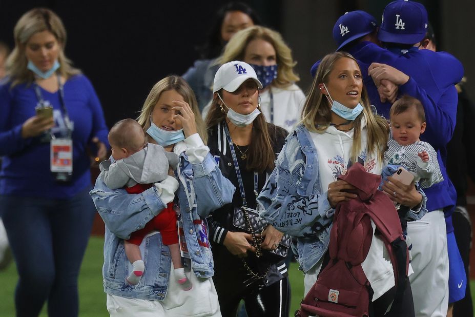 Family members of the Los Angeles Dodgers walk on the field to celebrate with the team.