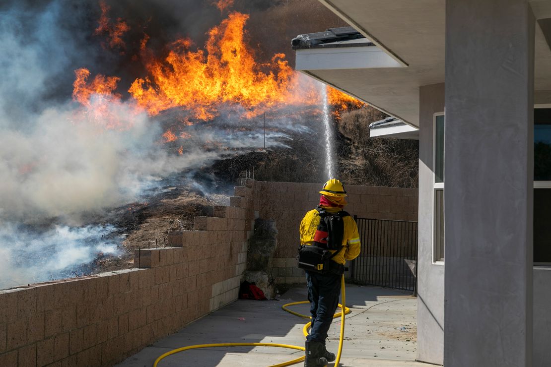 A firefighter protects a home from the Blue Ridge Fire.