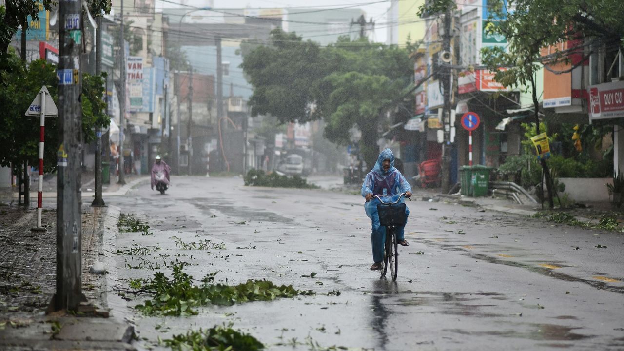 A man rides along a deserted road amid strong winds in central Vietnam's Quang Ngai province on Wednesday Typhoon Molave makes landfall.