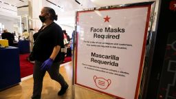 A woman wearing a face mask walks past a notice board with COVID-19 preventive instructions at a Macy's store in New York, United States, on Oct. 16, 2020. The total number of COVID-19 cases in the United States surpassed 8 million on Friday, according to the Center for Systems Science and Engineering CSSE at Johns Hopkins University. (Photo by Wang Ying/Xinhua/Getty Images)