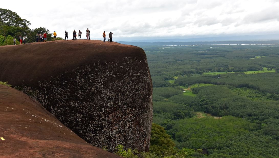 <strong>Bueng Kan Three Whale Rock: </strong>Domestic tourists stand on one of the largest of the sandstone boulders that make up the Three Whale Rock in Phu Pha Singh Forest Park in Bueng Kan province. The Mekong River is faintly visible on the horizon.