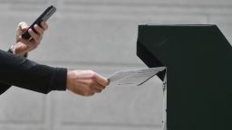 PHILADELPHIA, PA - OCTOBER 27:  A man photographs himself depositing his ballot in an official ballot drop box while a long line of voters queue outside of Philadelphia City Hall at the satellite polling station on October 27, 2020 in Philadelphia, Pennsylvania. 