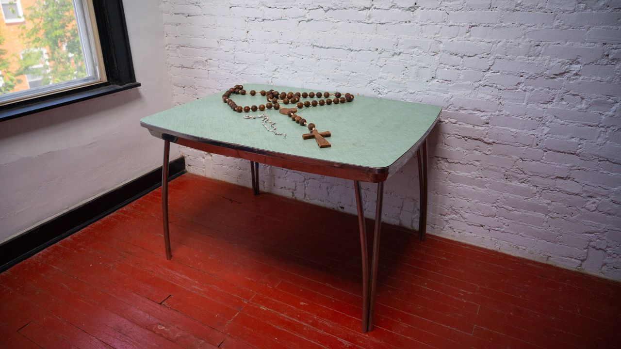 A rosary sits on a table in Rafael Alvarez's home. The room is now filled with donated rosaries.